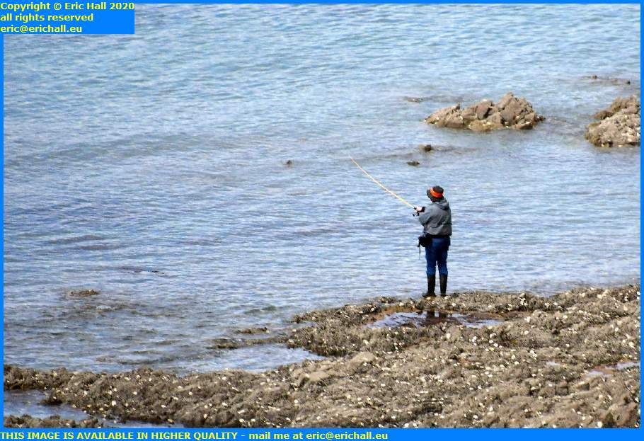 woman fishing from rocks plat gousset granville manche normandy france eric hall