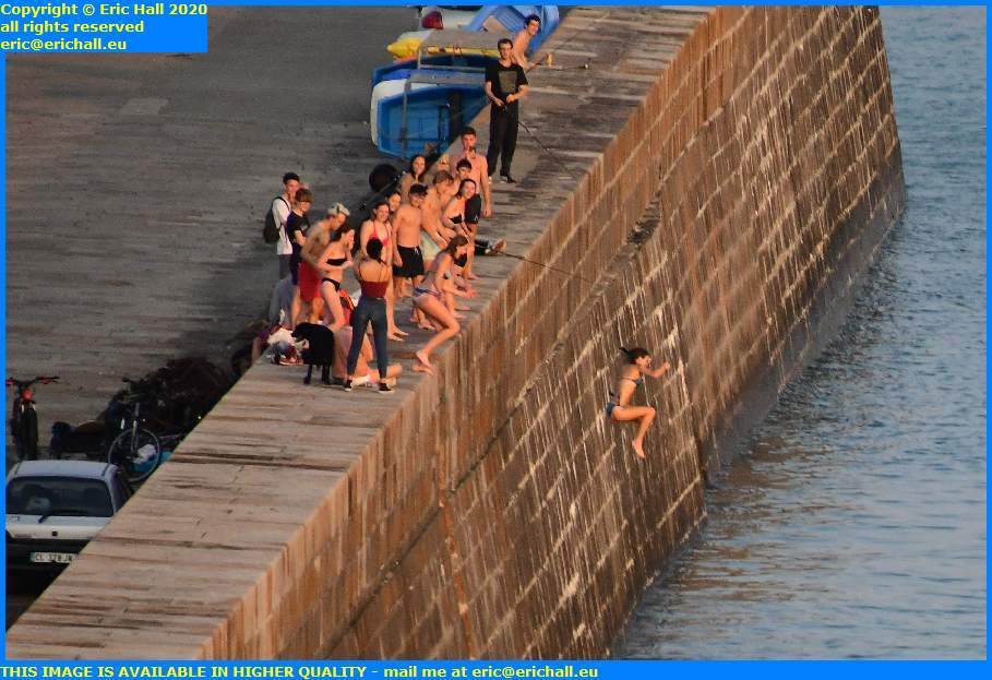 kids jumping off sea wall port de granville harbour manche normandy france eric hall