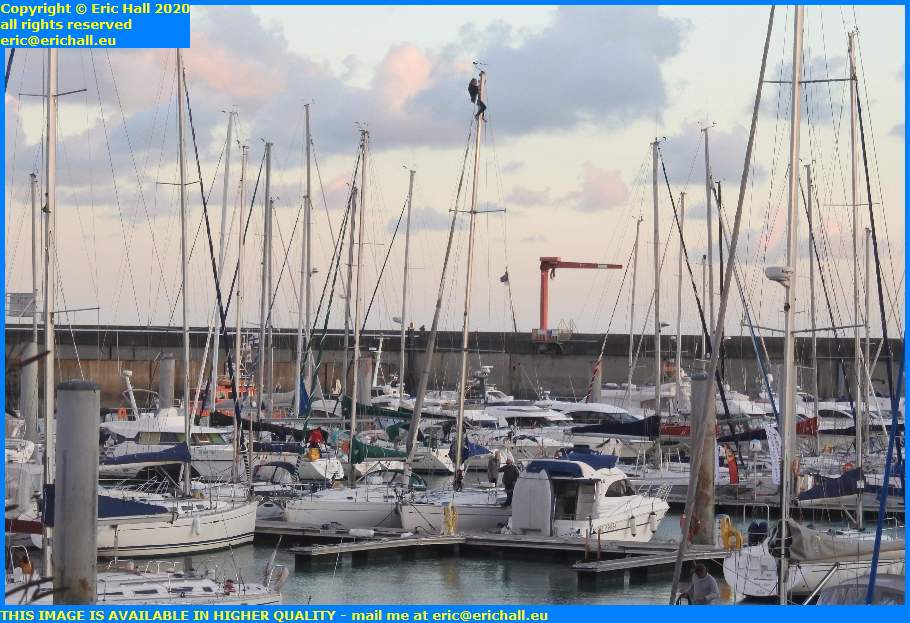 man working up mast port de granville harbour manche normandy france eric hall