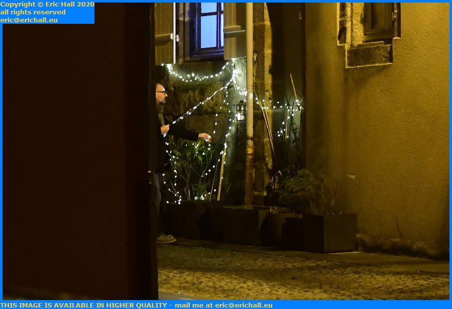 man installing christmas decorations rue st jean Granville Manche Normandy France Eric Hall