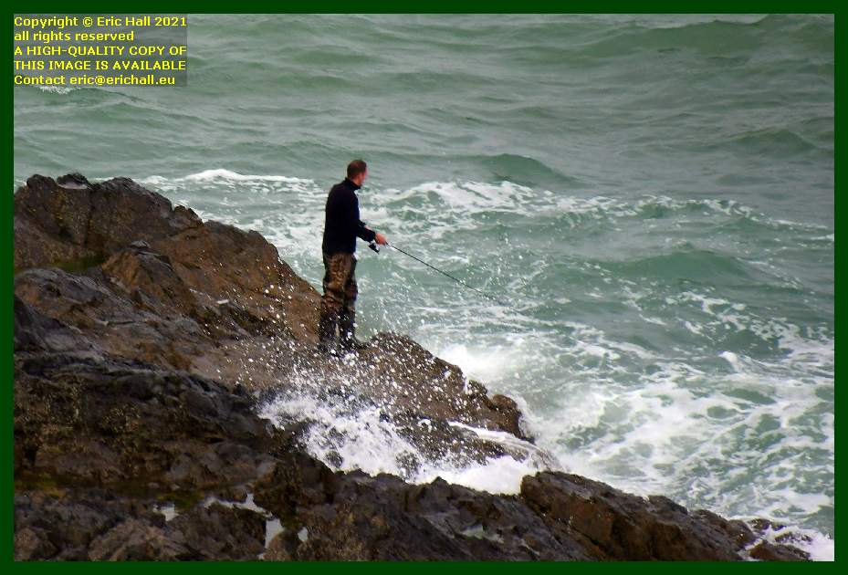 man fishing off rocks pointe du roc Granville Manche Normandy France photo Eric Hall June 2021